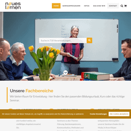 Lehrerin erklärt Seminarinhalten vor Gruppe in Schulungsraum.
