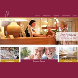 Freundliches Pflegepersonal im Gespräch mit Senioren in der Residenz.